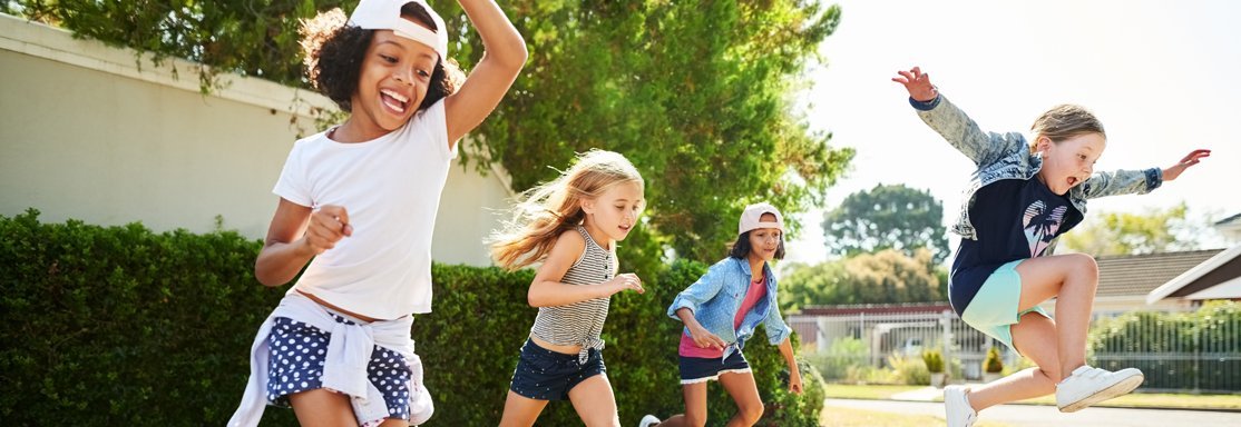 Groupe d’enfants qui courent et sautent en plein air, incarnant la joie, la liberté et l’énergie de l’enfance.