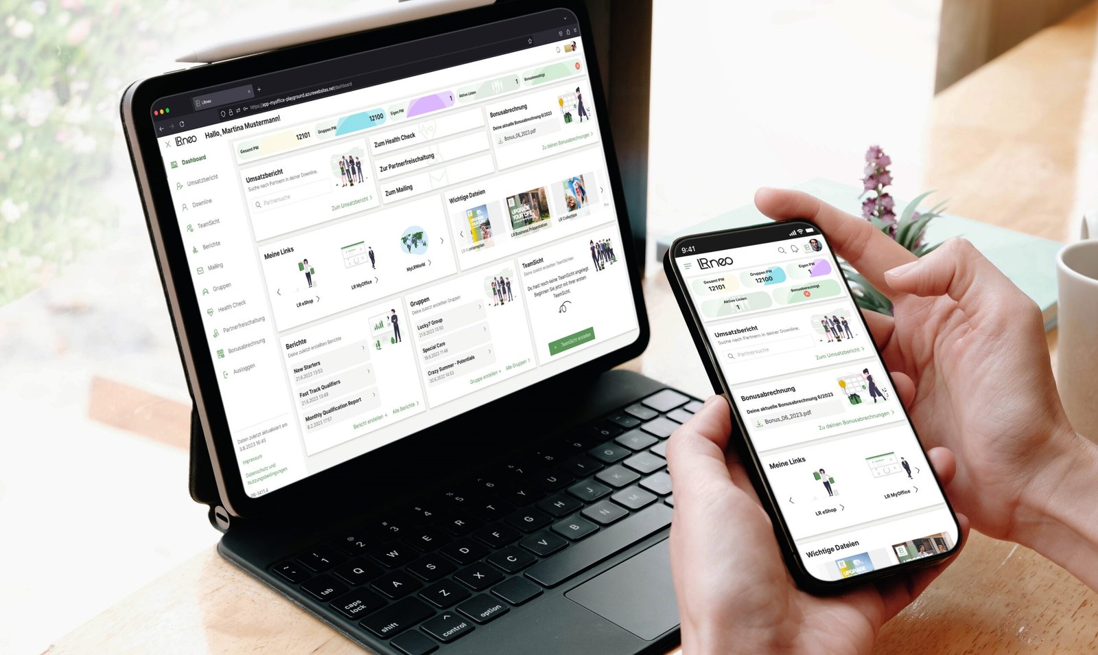 Mains tenant un smartphone et une tablette affichant le portail partenaire LR Health & Beauty