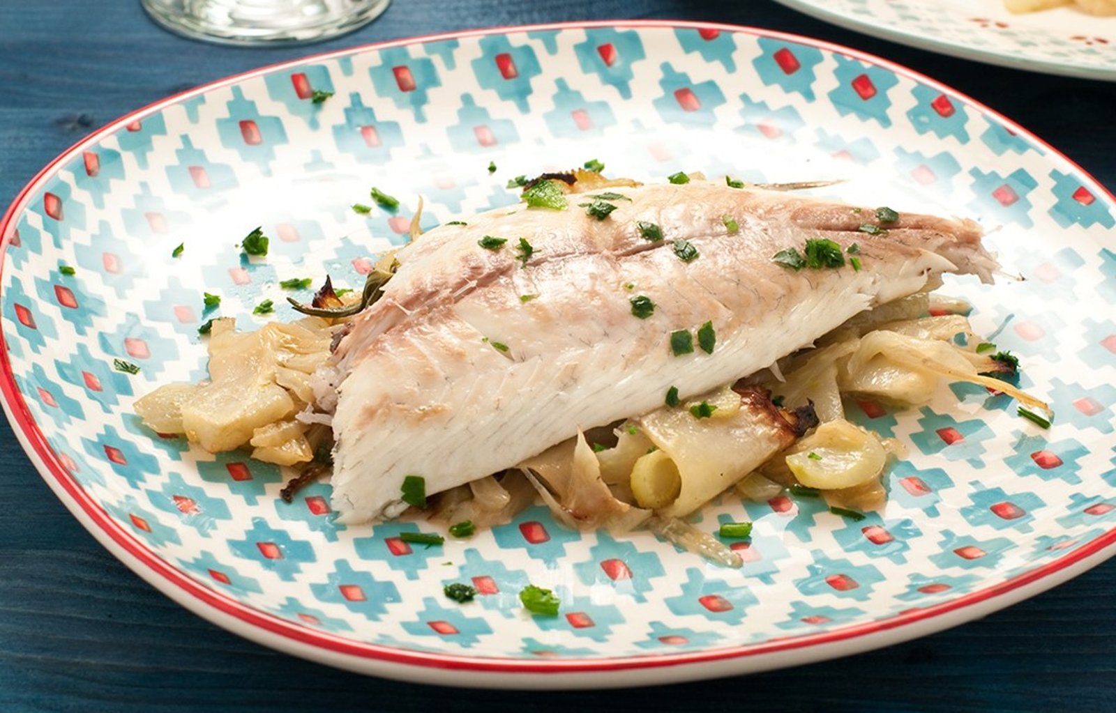 Filet de poisson blanc accompagné de pommes de terre et d'herbes sur une assiette